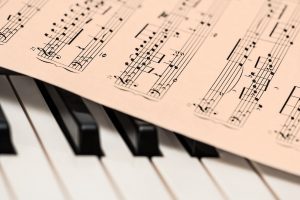 a sheet of music lies across piano keys